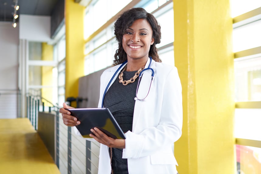 Portrait of a female doctor holding her patient chart on digital tablet in bright modern hospital Portrait of a female doctor holding her patient chart on digital tablet in bright modern hospital